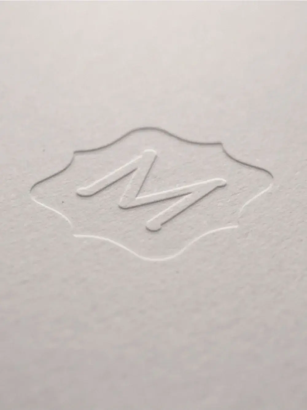 Embossed Metrie seal on white paper.
