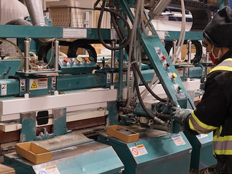 Employé de Metrie plaçant des montants sur une porte dans notre atelier de fabrication de portes